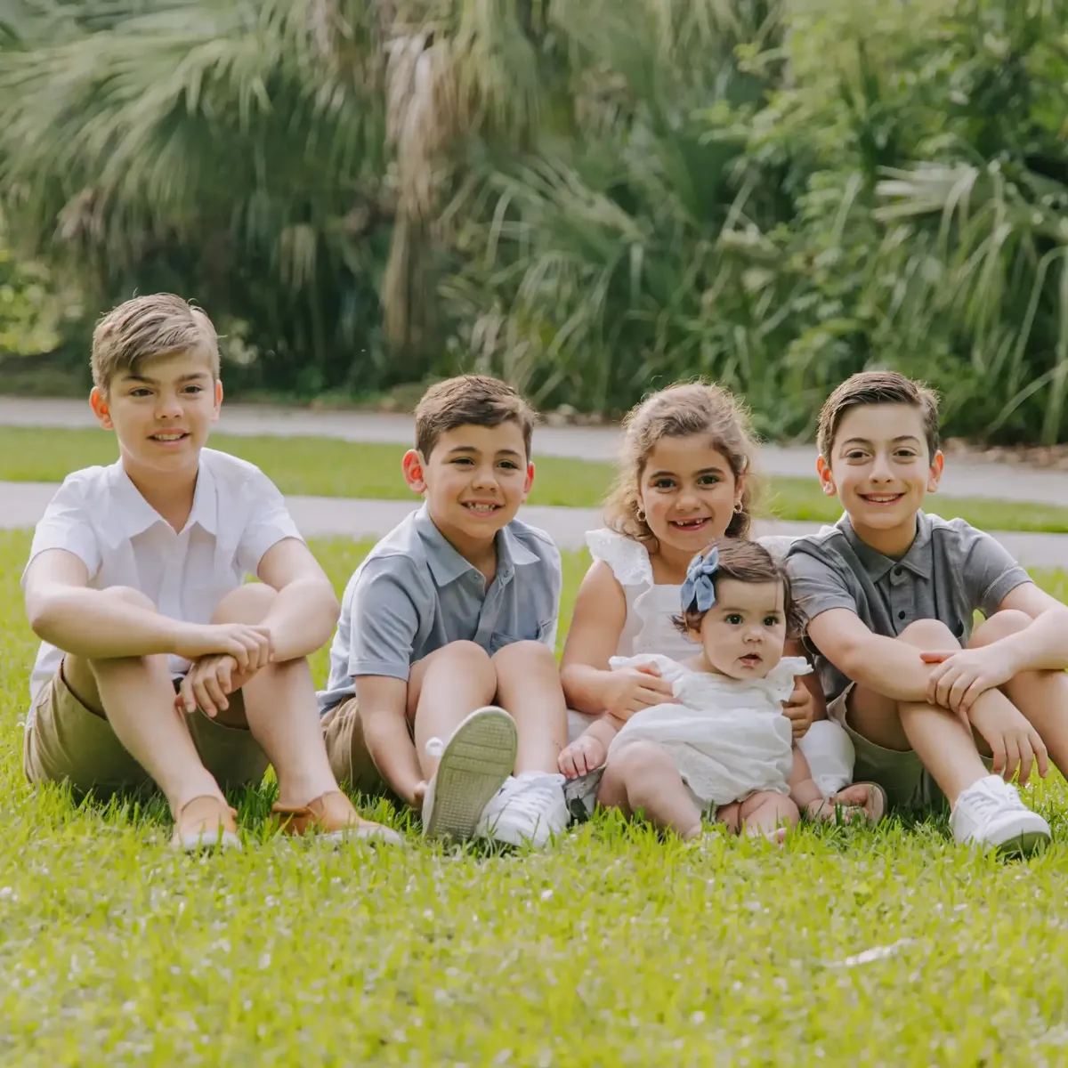 Five kids sitting together in the grass
