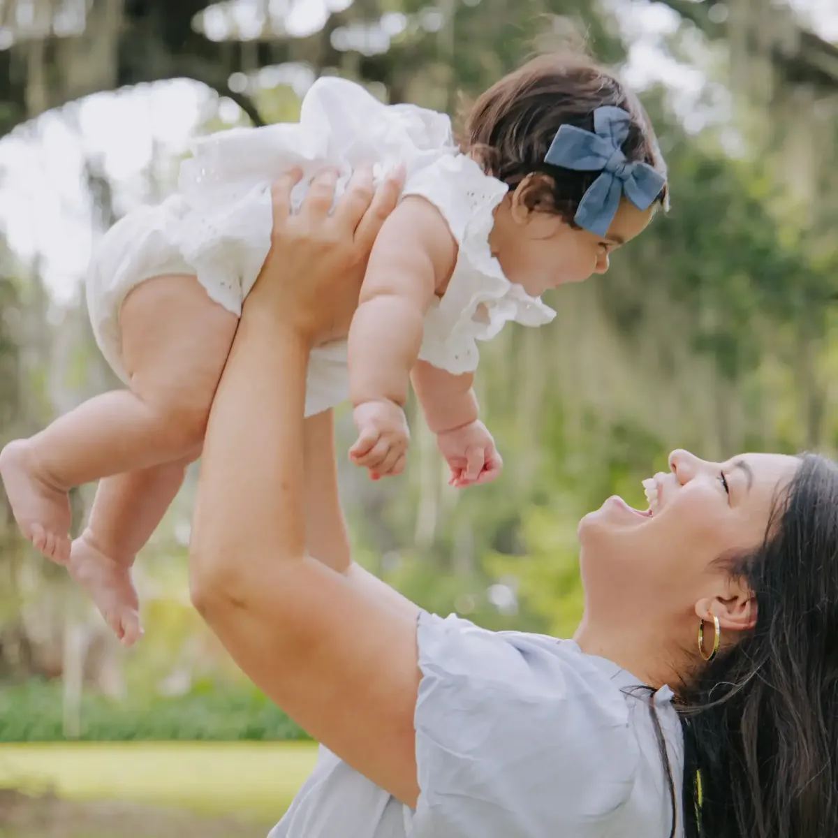 Mom lifting her baby overhead, laughing