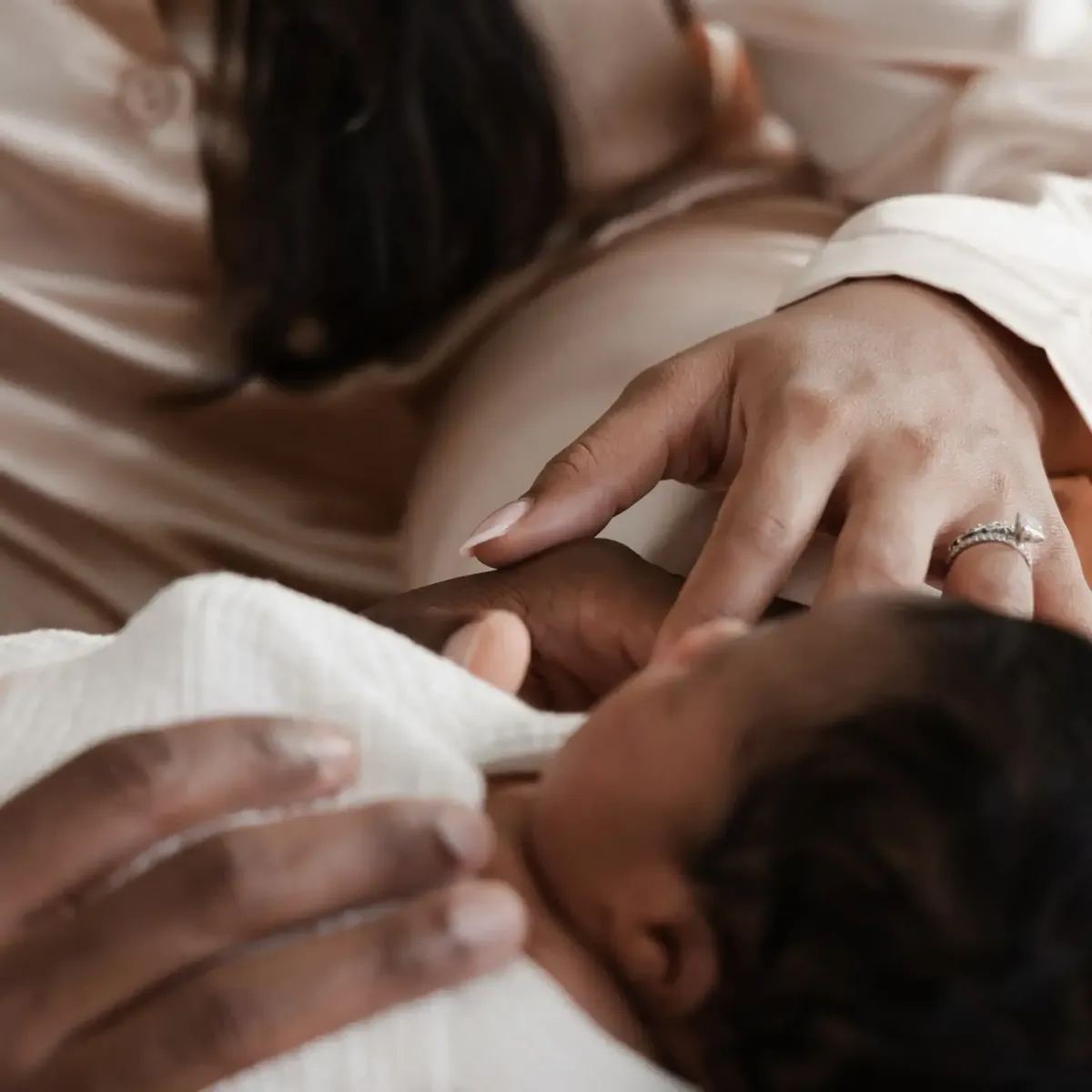 Newborn resting in parents' hands