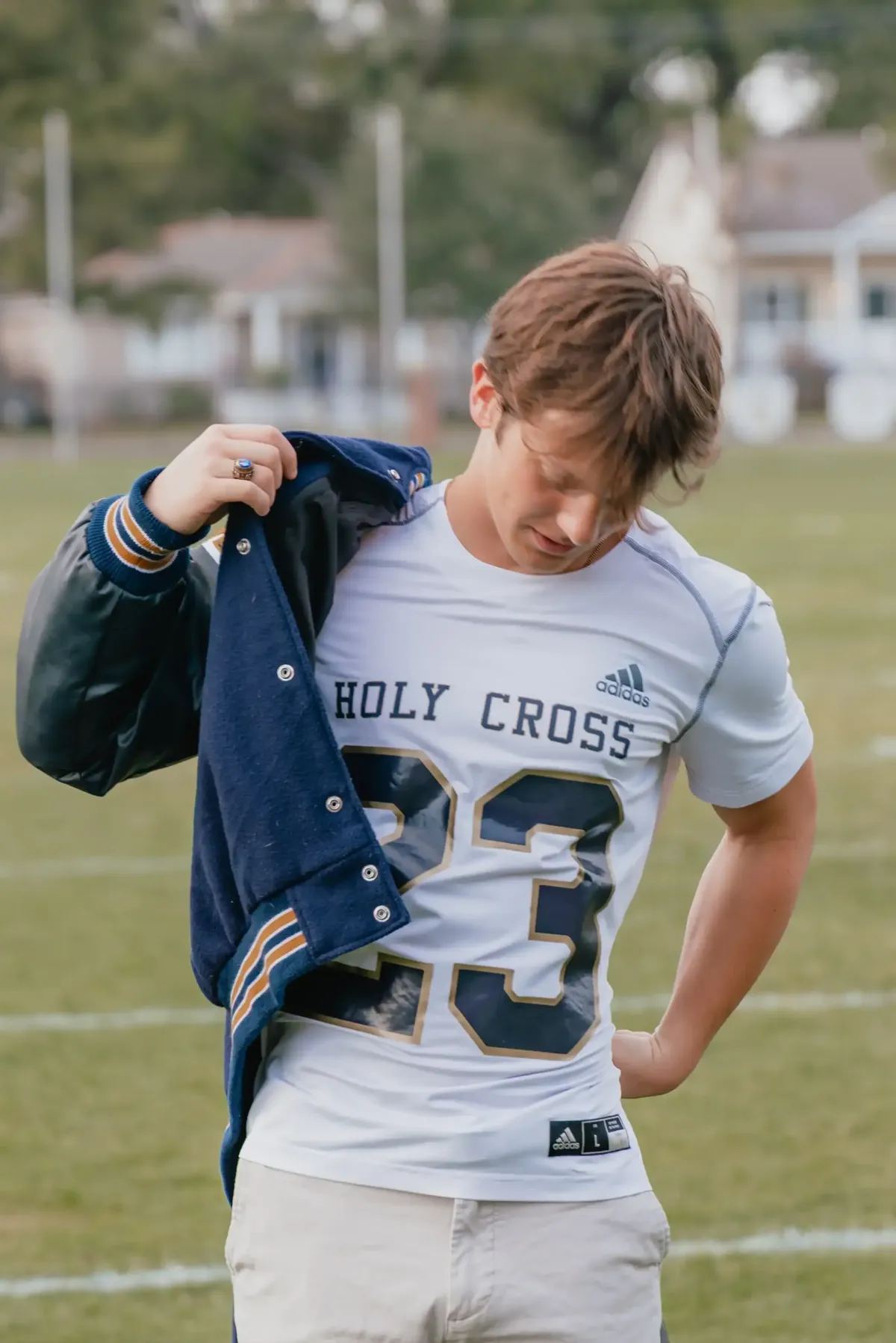 High-school senior with letterman jacket over his shoulder
