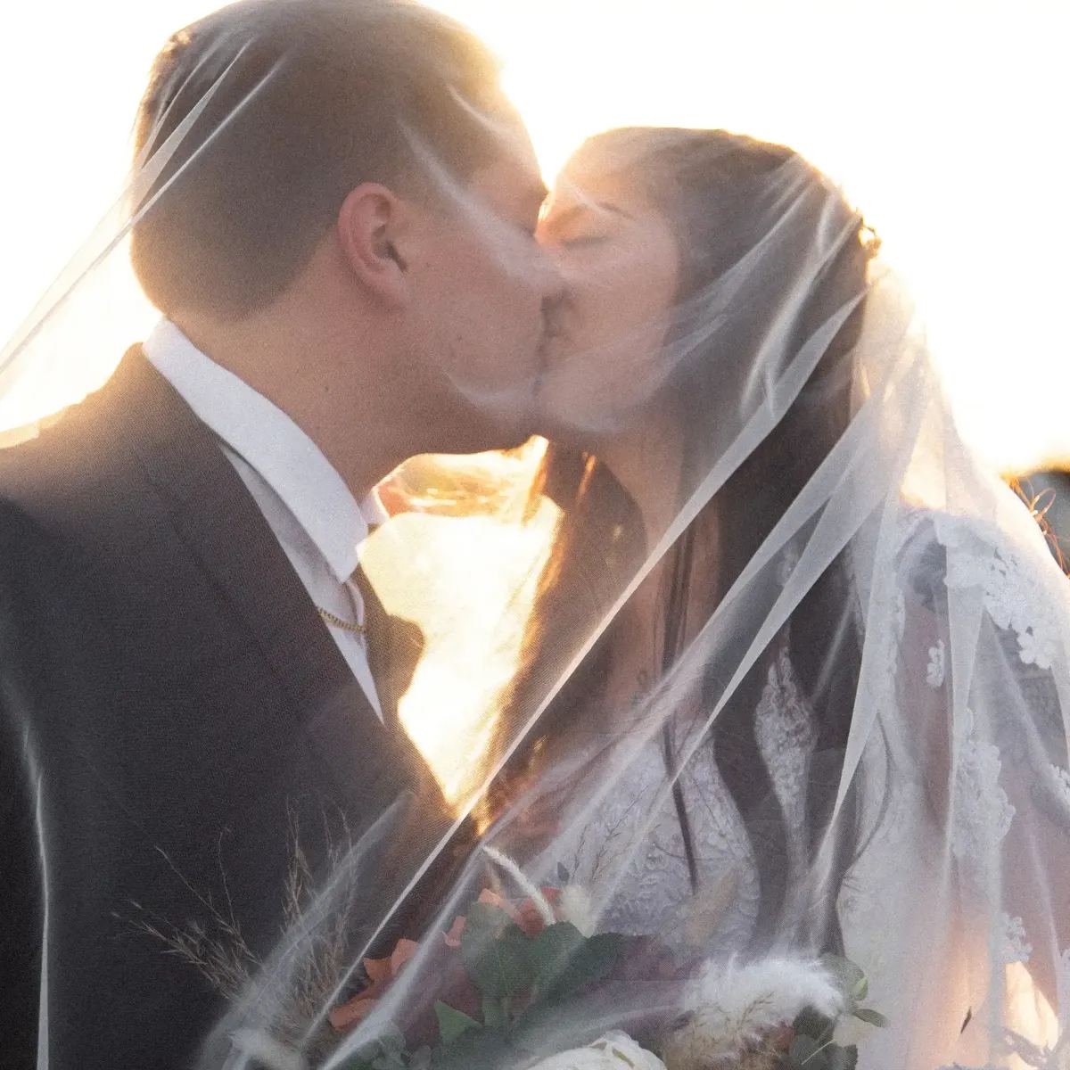 Couple kissing under the veil at golden hour