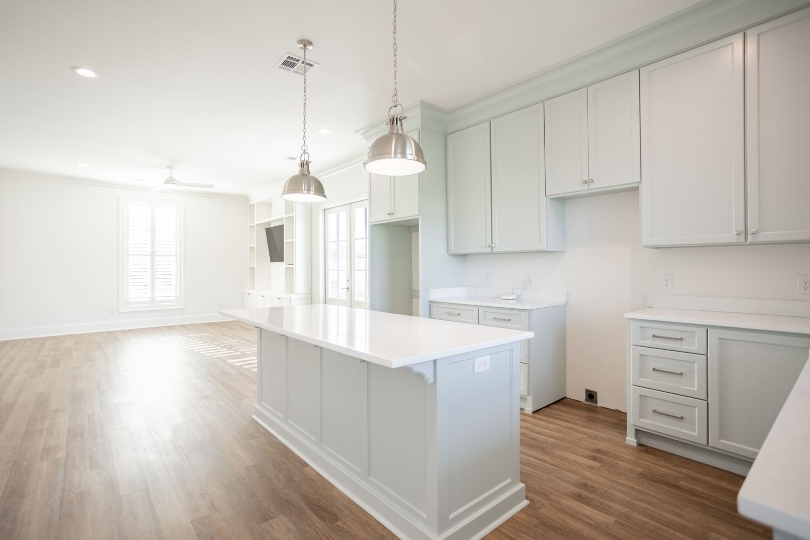 White kitchen with large island and pendant lighting