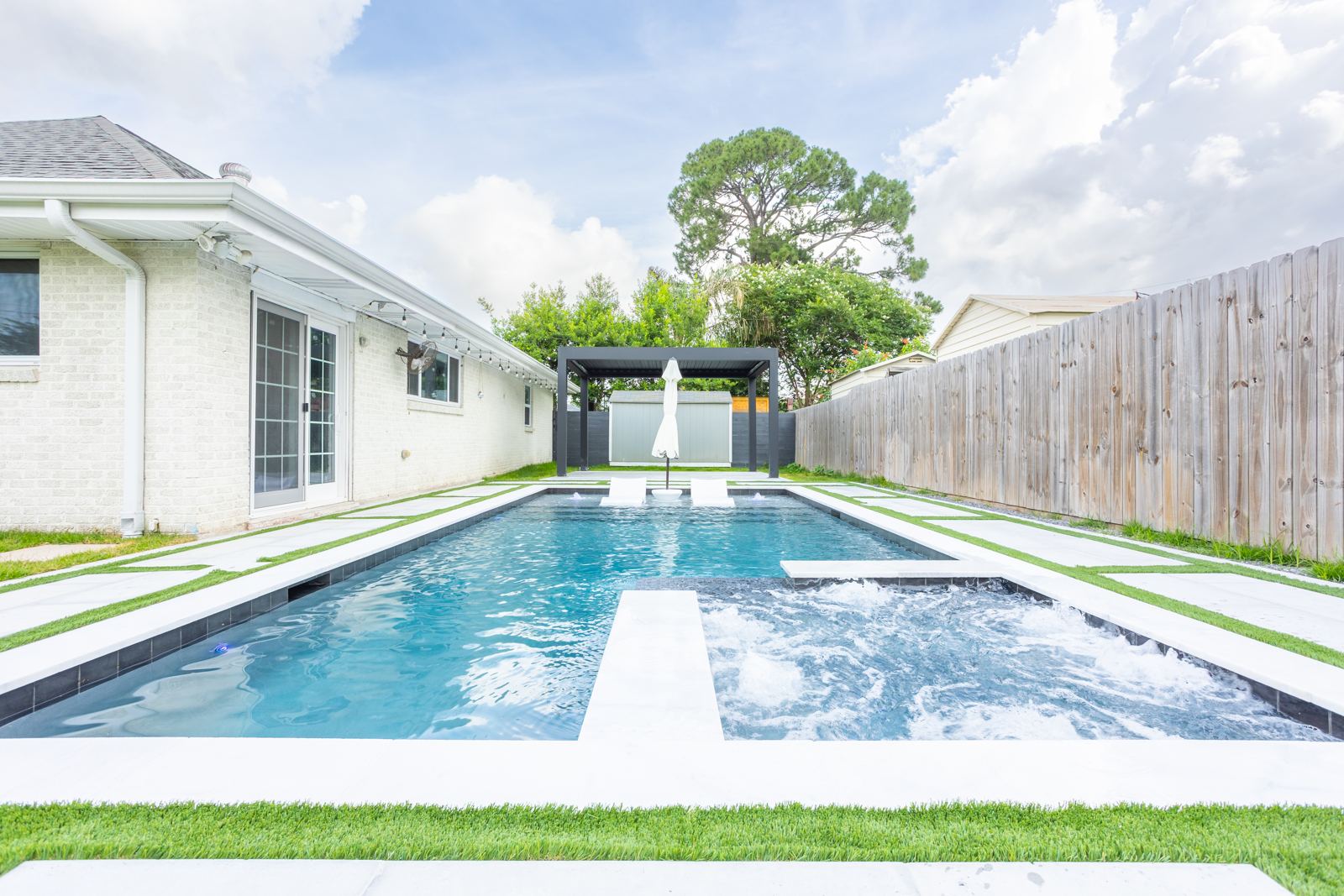 Long backyard pool with tanning ledge in Metairie